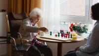 Senior woman playing game with caregiver
